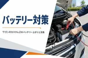 軽自動車のバッテリーに赤と黒のブースターケーブルをつないでいる手元